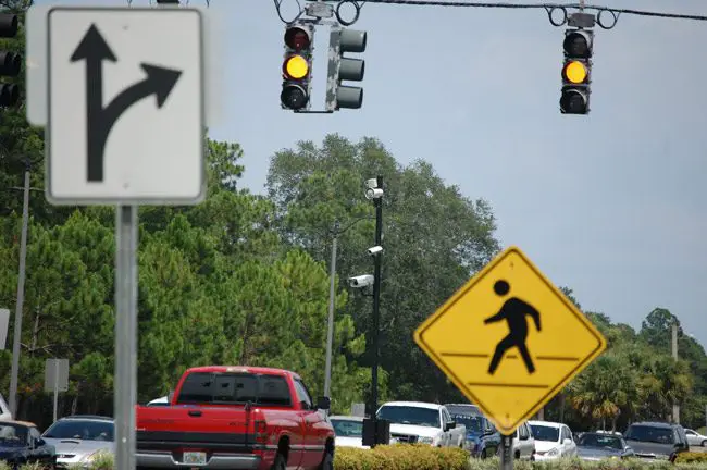 Pedestrians have benefited more from red-light cameras than have motorists, who have experienced a steep rise in crashes at camera-equipped intersections, according to a new report by the Florida Department of Highway Safety and Motor Vehicles. (© FlaglerLive)