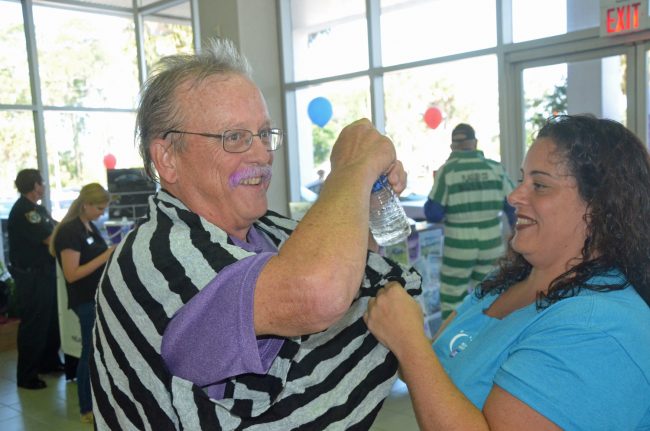 Steve Canfield, this year's Relay For Life organizer, gets prison-ready with past organizer Judy Mazzella. Click on the image for larger view. (© FlaglerLive)