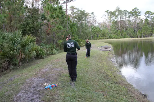 Flagler County Sheriff Crime Scene Investigations supervisor Laura Pazarena, foreground, and Lainey Weibling take measurements to determine where the remains were found. A resident looking for a toy drone stumbled upon the remains, about 100 feet into the woods. (FCSO)