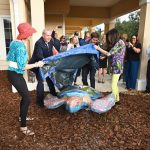 Renny is born: Artists Nancy Zedar and Lisa Fisher, palm Coast Mayor David Alfin and Intracoastal Bank President Ryan T. Page unveil the 21st sculpted turtle in the now five-year-old Turtle Trail, the largest public arts project in the county. Renny is positioned in front of the bank on Palm Coast Parkway. (© FlaglerLive)