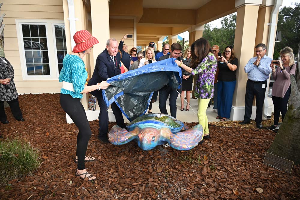 Renny is born: Artists Nancy Zedar and Lisa Fisher, palm Coast Mayor David Alfin and Intracoastal Bank President Ryan T. Page unveil the 21st sculpted turtle in the now five-year-old Turtle Trail, the largest public arts project in the county. Renny is positioned in front of the bank on Palm Coast Parkway. (© FlaglerLive)