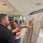 A resident whose property borders the northerm edge of the proposed development, speaking with ETM's Karl Soderholm, a landscape architect and planner, at the Wednesday "neighborhood meeting" at the Palm Coast Community Center. (© FlaglerLive)