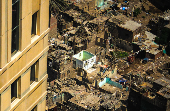 The slums of Cairo's Ramlet Boulaq, spread out beneath Nile City's gleaming towers, lack almost all modern conveniences, such as plumbing and electricity. The image is part of a series by Al-Jazeera on the rich-poor divide in Cairo.