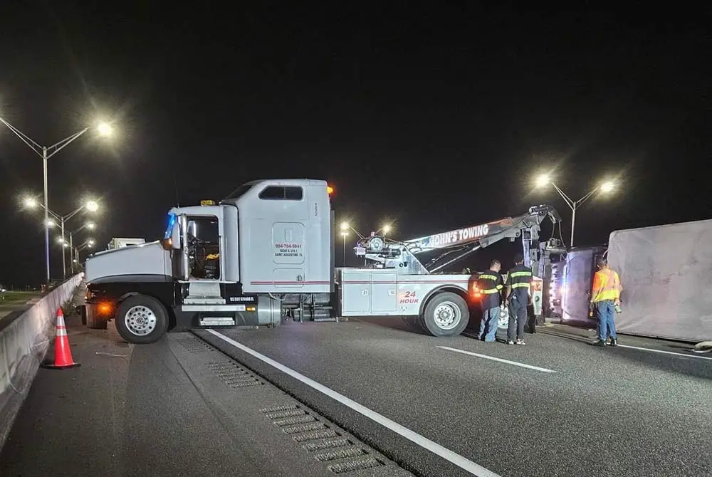 The semi in the first crash overturned across the guardrails. Towers worked to right the truck. The northbound lanes were closed. (© FlaglerLive)