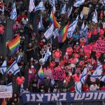 Demonstrators lift Israeli flags and LGBTQ pride flags during a protest against the proposed judicial overhaul in Tel Aviv in May 2023. (Ahmad Gharabli/AFP via Getty Images)