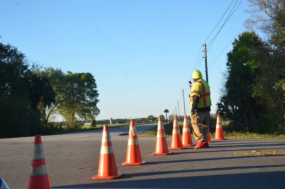 A member of the Palm Coast Fire Police at the intersection of State Road 100 and County Road 205 was diverting eastbound traffic onto County Road 205. (© FlaglerLive)