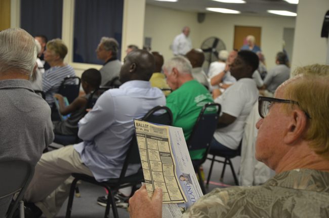 A voter samples the August primary ballot before sampling candidates for Palm Coast City Council at a town hall-style forum at the Belle Terre Swim and Racquet Club Wednesday evening. (© FlaglerLive)