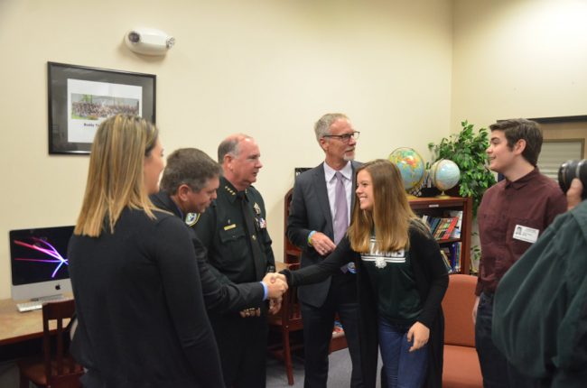 School Board Chairman Trevor Tucker shook hands with Alyssa Santore, a member of the Flagler Palm Coast High School Student Government Association, who was there with SGA President Tyler Perry, right. Click on the image for larger view. (© FlaglerLive)