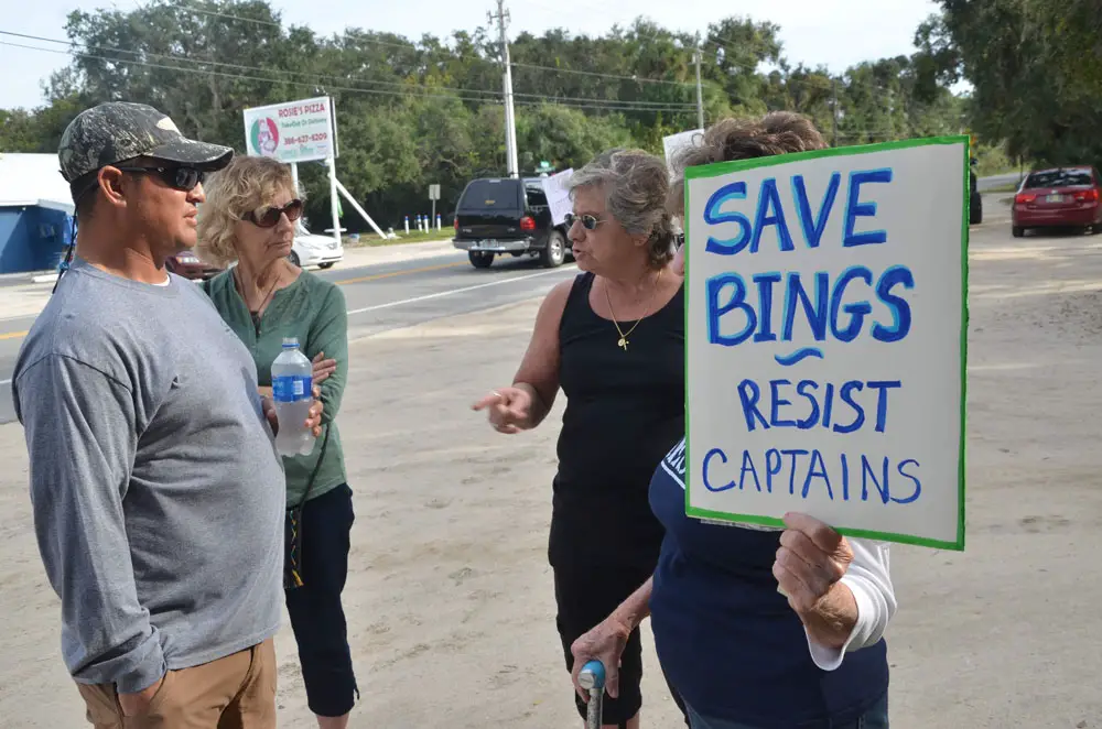 Captain's co-owner Chris Herrera, left, speaking with protesters in November 2018, days after the county commission had approved a lease agreement with the restaurant, and days before it would reconsider it. (© FlaglerLive)