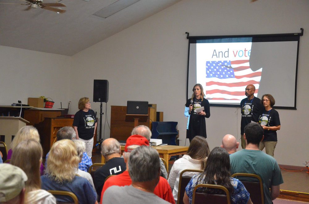 Preserve Flagler Beach President Elizabeth Hathaway was joined by Ken Bryant, the organization's vice president, and former County Commissioner Barbara Revels, a core member of the group, during a Q&A session at the end of Thursday evening's community meeting on The Gardens development. The meeting drew some 100 people. (© FlaglerLive)