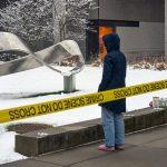 A person mourns at a makeshift memorial outside the Barus and Holley engineering building on the campus of Brown University in Providence, R.I., on Dec. 14, 2025.
