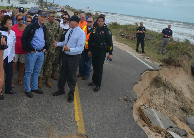 Gov. Rick Scott this morning in Flagler Beach, getting a quick briefing on A1A's coming needs from U.S. Rep. John Mica, chairman of the House Transportation Committee. (c FlaglerLive)