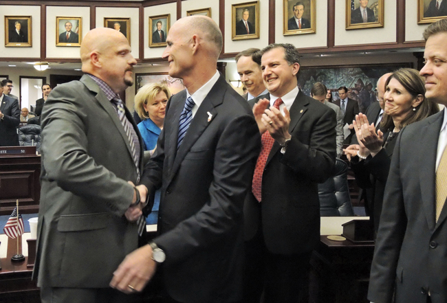 Finance and Tax Subcommittee Chair Ritch Workman, R-Melbourne, is congratulated on the House floor by Governor Rick Scott upon approval of a bill that would cut vehicle and driver’s license fees March 20, 2014. (Mark Foley)