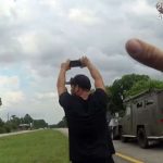 With numerous weapons trained on him, Joshua Siedel was intent on protecting his phone down to the last moment before he was handcuffed after a two-hour standoff on U.S. 1 Wednesday afternoon. (© FlaglerLive via FCSO video)