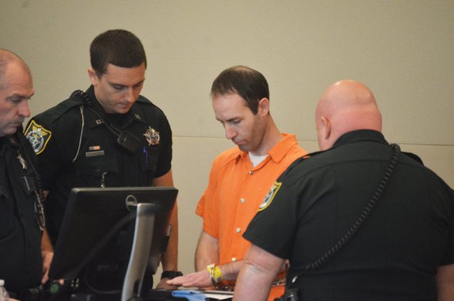 Sean Stern getting finger-printed after the sentence this morning at the Flagler County courthouse. He faces more charges in Texas. (© FlaglerLive)