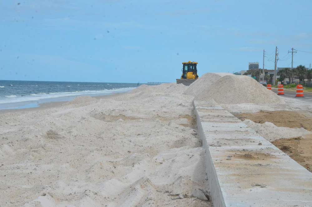 The so-called "secant wall" at the north end of Flagler Beach as its construction and burial in sand was completing in August 2019. The sand did not last, and by the time Hurricane Nicole struck last fall, it was already all gone, exposing the wall's rather scabrously ribbed piles over the beach. (© FlaglerLive)