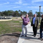 Danny Ashburn, Palm Coast's utility manager for the wastewater division, describes to Barry Cotton, Sen. Rick Scott’s Central Florida District Director, and City Council member Charles Gambaro, where Wastewater Treatment Plant 1's expansion would be built. To the right are Interim City Manager Lauren Johnston and Chief of Staff Jason DeLorenzo. (© FlaglerLive)