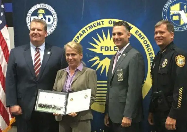 Sergeant Jennifer Taylor holding her graduation certificate at Florida Leadership Academy
