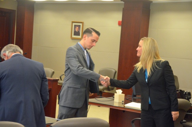 Shannon Kelly, one of the two lawyers for Publix, extended her hand to the plaintiff, Robert Barry, after the verdict, as Barry's lawyer, Frederick Morello, tidied up. (© FlaglerLive)