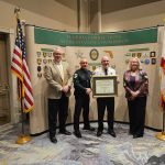 FCAC Executive Director Stacy Lehman (L) and Chair of the Board of Commissioners Chief Laura Bedard (R), award Chief Daniel Engert and Sheriff Rick Staly the Certificate of Reaccreditation.