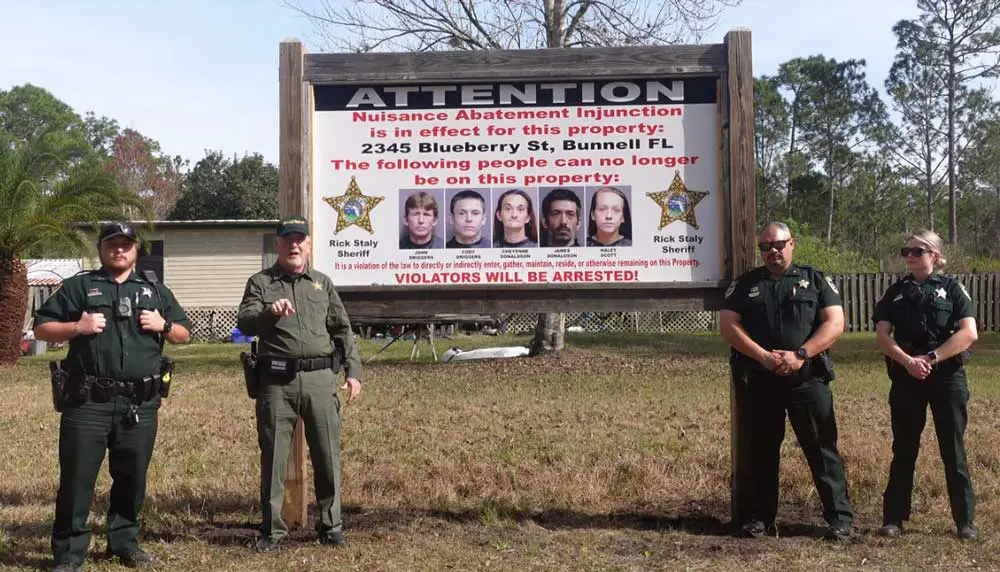 Flagler County Sheriff Rick Staly, second from left, outlining the agency's novel approach to evicting a homeowner and residents who'd drained sheriff's resources with their criminal activity. (© FlaglerLive via Sheriff's Office video)