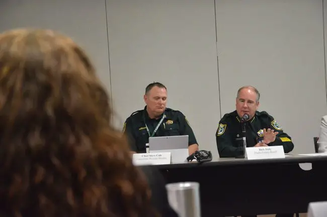Sheriff Rick Staly, right, described the likely financial impact of a shift in inmates from the state back to the counties, during a meeting of the Public Safety Coordinating Council last week. Steve Cole, who oversees the local jail, is to his right, with County Judge Melissa Moore-Stens in the foreground. (© FlaglerLive)