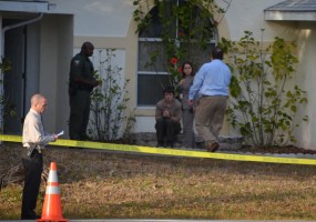 Brandon Williamson sat outside the house where the shooting took place, his hands bloody, shortly before being driven away by sheriff's officials. Click on the image for larger view. (© FlaglerLive)