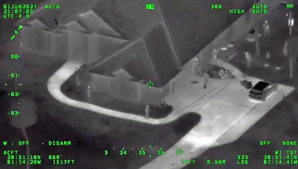 Volusia County sheriff's deputies scour the home in Deltona where Nicole Jackson and a 12-year-old boy both armed themselves heavily and fired at deputies. The still is from a Volusia Air One helicopter video. 