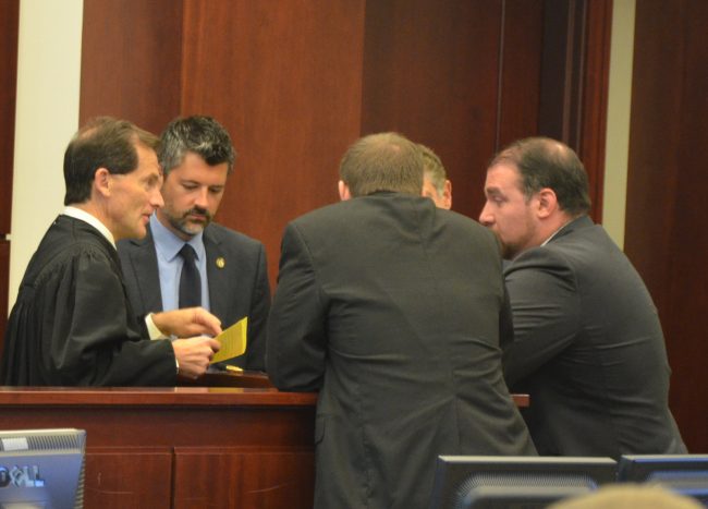 In an exteremly tightly lawyered trial, the attorneys had innumerable sidebars with Circuit Judge Dennis Craig, left. Second from left is Assistant State Prosecutor Joe LeDonne. (© FlaglerLive)