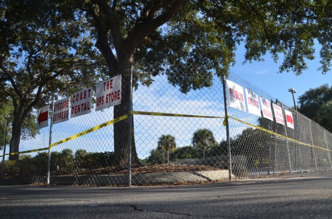 At Palm Harbor Shopping Center, it's now a story of signs and fencing. (© FlaglerLive)