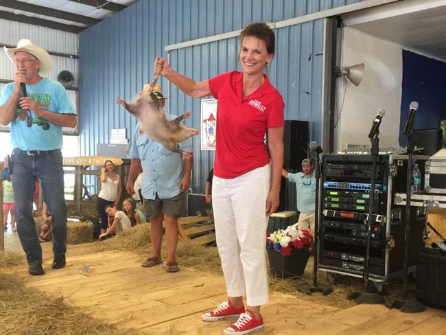 Candidate for Commissioner of Agriculture Denise Grimsley slings around the possum she won at the the Wausau Possum Festival in Washington County on Aug. 4. (NSF)