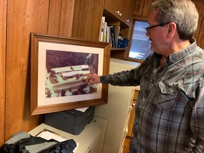 Duane Sizemore describes from an old picture in his office the gradual additions to his business along a block on South Bay Street in Bunnell. (© FlaglerLive)