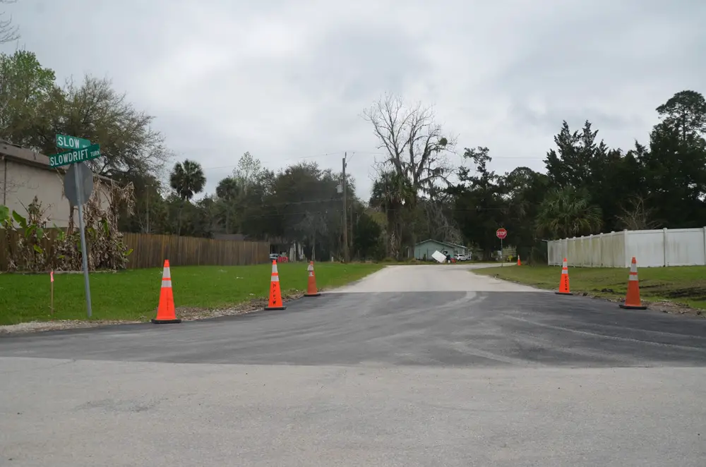 Ironically, the city is repairing Slow Turn even as it is considering closing it permanently. The Palm Coast City Council on Tuesday opted to delay the decision. Above, Slow Turn, at the intersection with Slowdrift Lane, as it looked this afternoon. (© FlaglerLive)