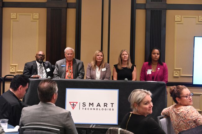 It wasn;t just a sponsorship tagline. The participants at today's Chamber forum were, from left, Bunnell City Manager Alvin Jackson, Flagler Beach City Manager Dale Martin, Flagler County Administrator Heidi Petito, Palm Coast City Manager Lauren Johnston, and School Superintendent LaShakia Moore. (© FlaglerLive)