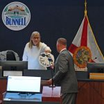 Brannon Snead receiving a token of the city's appreciation for his interim role as police chief, from Mayor Catherine Robinson, at last Monday's City Commission meeting. (© FlaglerLive)