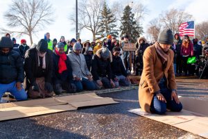 Imam Yusef Abdulle leads the afternoon prayer as dozens of demonstrators gather outside of Minneapolis-St. Paul Airport to protest deportation flights that regularly fly out of MSP Wednesday, Dec. 3, 2025. (Photo by Nicole Neri/Minnesota Reformer)
