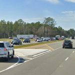 Traffic on State Road 100 in Palm Coast, just west of the BJ's Wholesale shopping center, with the future Flagler Landing shopping center property to the left, where all the trees are. That development, likely to add a Walmart as the next big box store, is expected to bring upwards of 3,000 more daily car trips to the corridor. (© FlaglerLive)