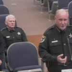 Flagler County Sheriff Rick Staly addressing a joint meeting of the Palm Coast City Council and the County Commission this morning, with Palm Coast Acting City Manager Lauren Johnston and Sheriff's Chief of Staff Mark Strobridge. (© FlaglerLive via Flagler TV)