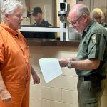 Sheriff Rick Staly reading Kermit Booth his warrant. (FCSO)