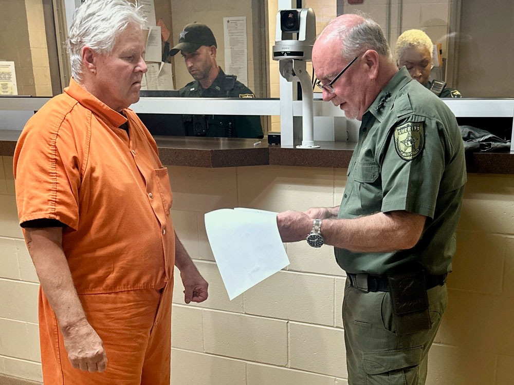 Sheriff Rick Staly reading Kermit Booth his warrant. (FCSO)