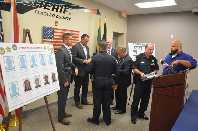 Sheriff Rick Staly, second from left, speaking with News-Journal reporter Matt Bruce after this morning's press conference. Behind him were State Attorney R.J. Larizza, immediately to Staly's left, Bunnell Police Chief Tom Foster, and federal officials. (© FlaglerLive)