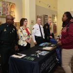 From left, Deputy Towns, Assistant HR Director Lynch, and Sheriff Staly talk to a student during the Career Symposium. (FCSO)