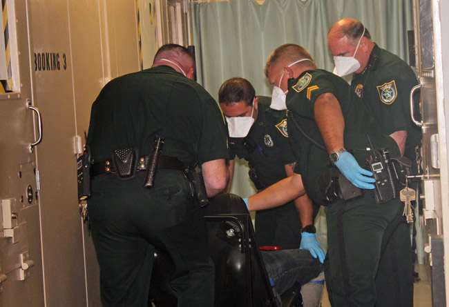 Sheriff Rick Staly, right, happened to be at the Flagler County jail this morning when corrections deputies conducted a forced extraction of inmate Michael Grube, who had allegedly refused to cooperate in all manners and declared himself a 'sovereign citizen' who did not have to abide by laws or directions, and so was [placed in a restraint chair. He later relented and was booked. (FCSO)