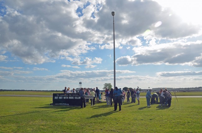 Protesters, including, for the first time, a group from Flagler County, getting set for a prayer service and vigil before the execution of Larry Eugene Mann at Starke state prison, in the background. Click on the image for larger view. (© FlaglerLive)