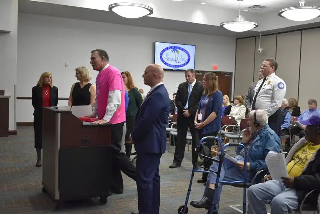 Florida Hospital Flagler's John Subers, center, in the pink shirt, presenting the $14,448 check raised by this year's Pink Army run for breast cancer awareness and treatment locally. The presentation was before the Palm Coast City Council this morning. (Palm Coast)