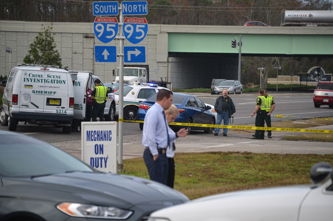 Investigators at the scene this morning. The apparent suicide took place in the blue car just before the intersection with I-95, on State Road 100. (c FlaglerLive)