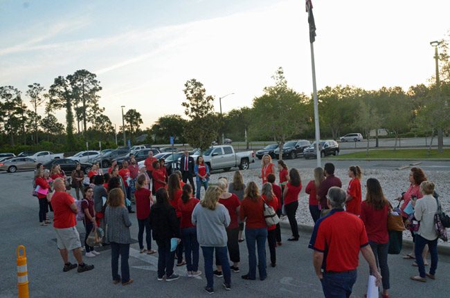 Just before sun-up at Indian Trails Middle School, walk-in participants, including teachers, administrators service employees and students, gathered at the flagpole, as they would at all nine of the county's traditional public schools this morning. (© FlaglerLive)