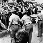 Policemen keep a mob back as James Meredith, a Black student trying to enroll at the University of Mississippi, is driven away after being refused admittance to the all-white university in Oxford on Sept. 25, 1962.