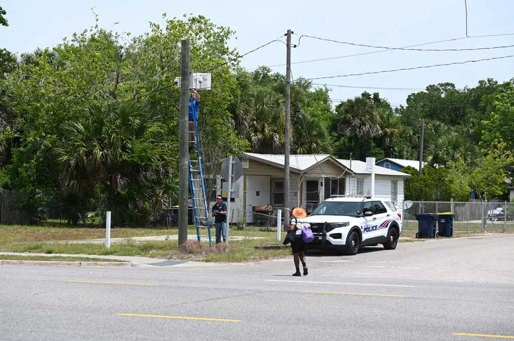 Workers at a city-owned surveillance camera at the corner of Martin Luther King Jr. Boulevard and U.S. 1 in early May. (© FlaglerLive)
