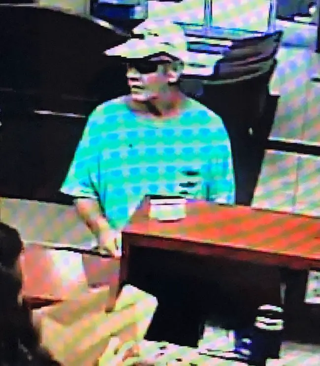 The man believed to be Gary Rahme at Ameris Bank on July 12 as a teller apears to be preparing a bag of money for him. The image was released by the St. Johns County Sheriff's Office. 